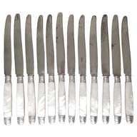 12 couteaux de table de style Louis XV, manche en nacre, viroles en argent, par Olier et Caron