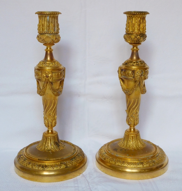 Paire de bougeoirs de style Louis XVI en bronze ciselé et doré