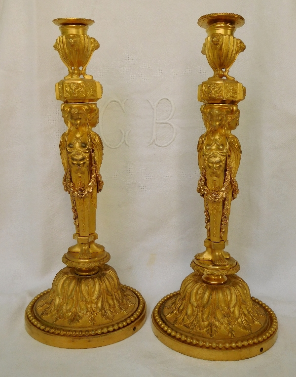 D'après Jean-Demosthene Dugourc : paire de bougeoirs / flambeaux en bronze doré de style Louis XVI