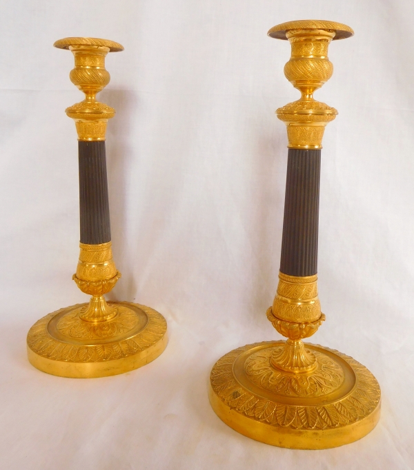 Pair of patinated bronze and ormolu candlesticks, early 19th century