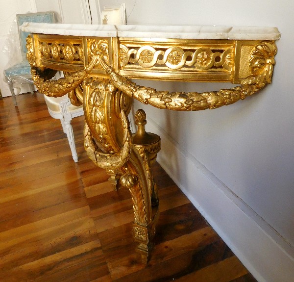 Console demi-lune en bois doré richement sculptée d’époque Louis XVI
