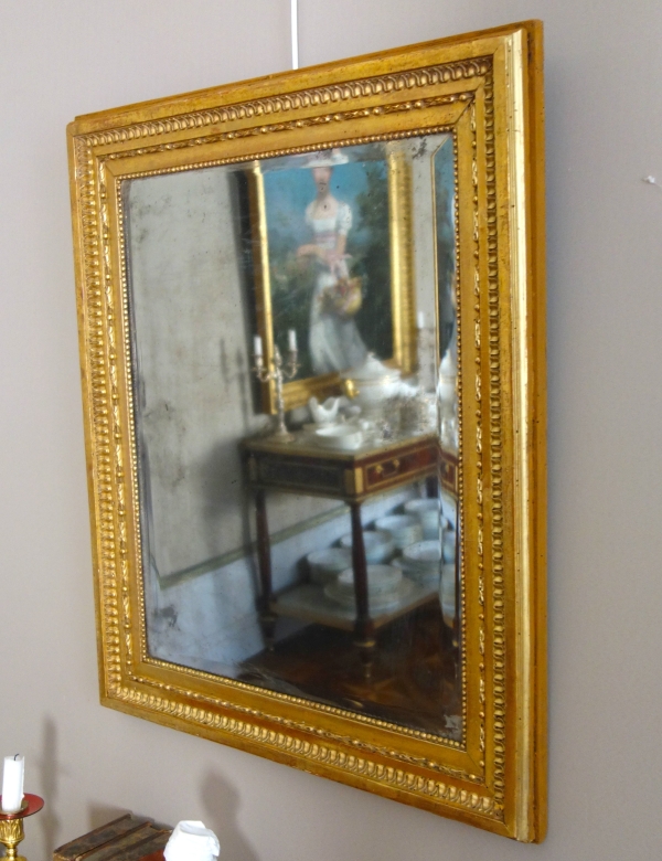Miroir de boiserie à suspendre en bois doré à la feuille d'or, glace mercure - époque Louis XVI