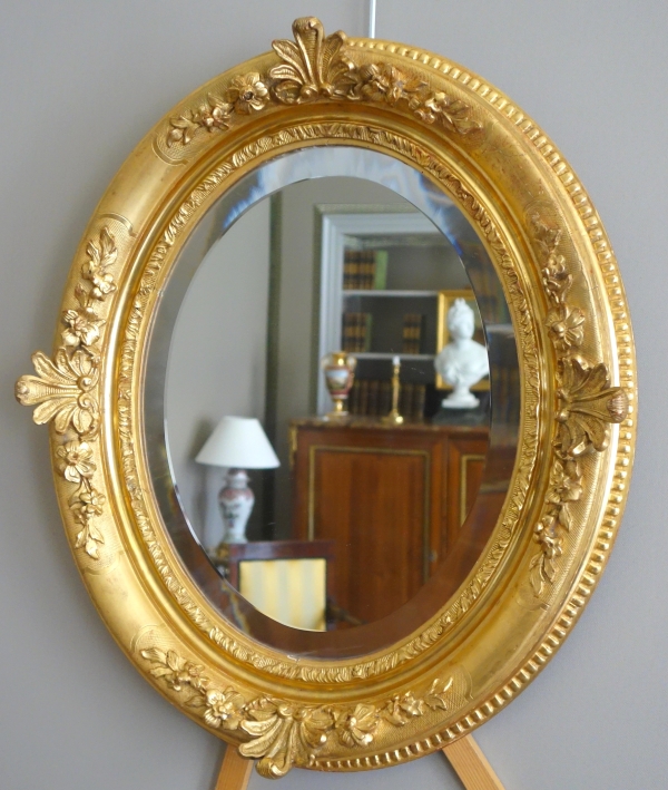 Miroir ovale de style Louis XIV, bois doré à la feuille d'or, glace biseautée - 58,5cm x 68cm