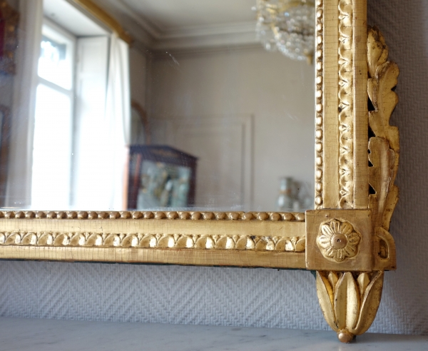 Grand miroir en bois doré d'époque Louis XVI, modèle provençal, fronton à trophée de musique