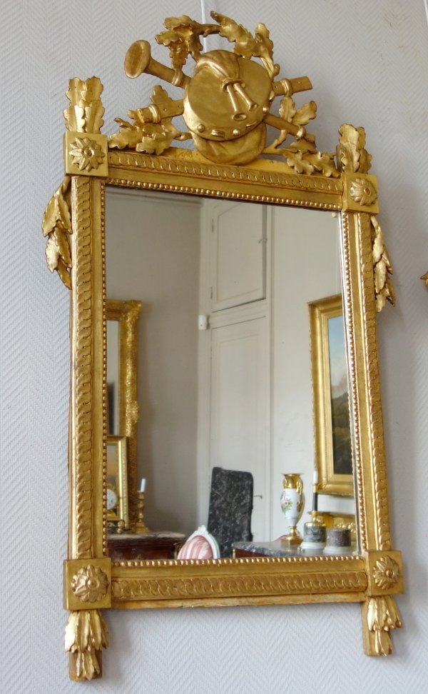 Grand miroir provençal d'époque Louis XVI en bois doré, fronton à trophée de musique