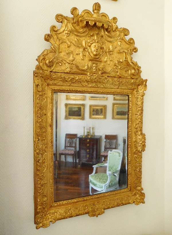 Miroir à fronton en bois doré d'époque Régence, masque d'Indienne, glace au mercure XVIIIe