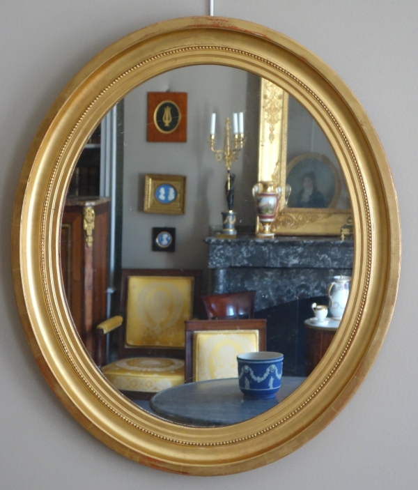 Paire de grands miroirs ovales en bois doré, glace au mercure - style Louis XVI