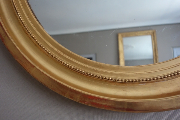 Paire de grands miroirs ovales en bois doré, glace au mercure - style Louis XVI