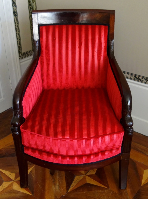 Empire mahogany bergere, dolphin-shaped armrests, early 19th century
