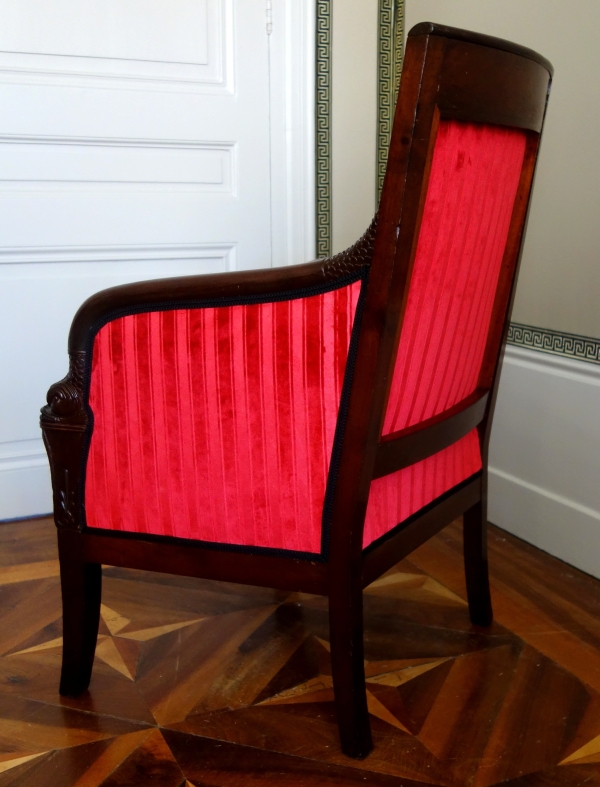 Empire mahogany bergere, dolphin-shaped armrests, early 19th century