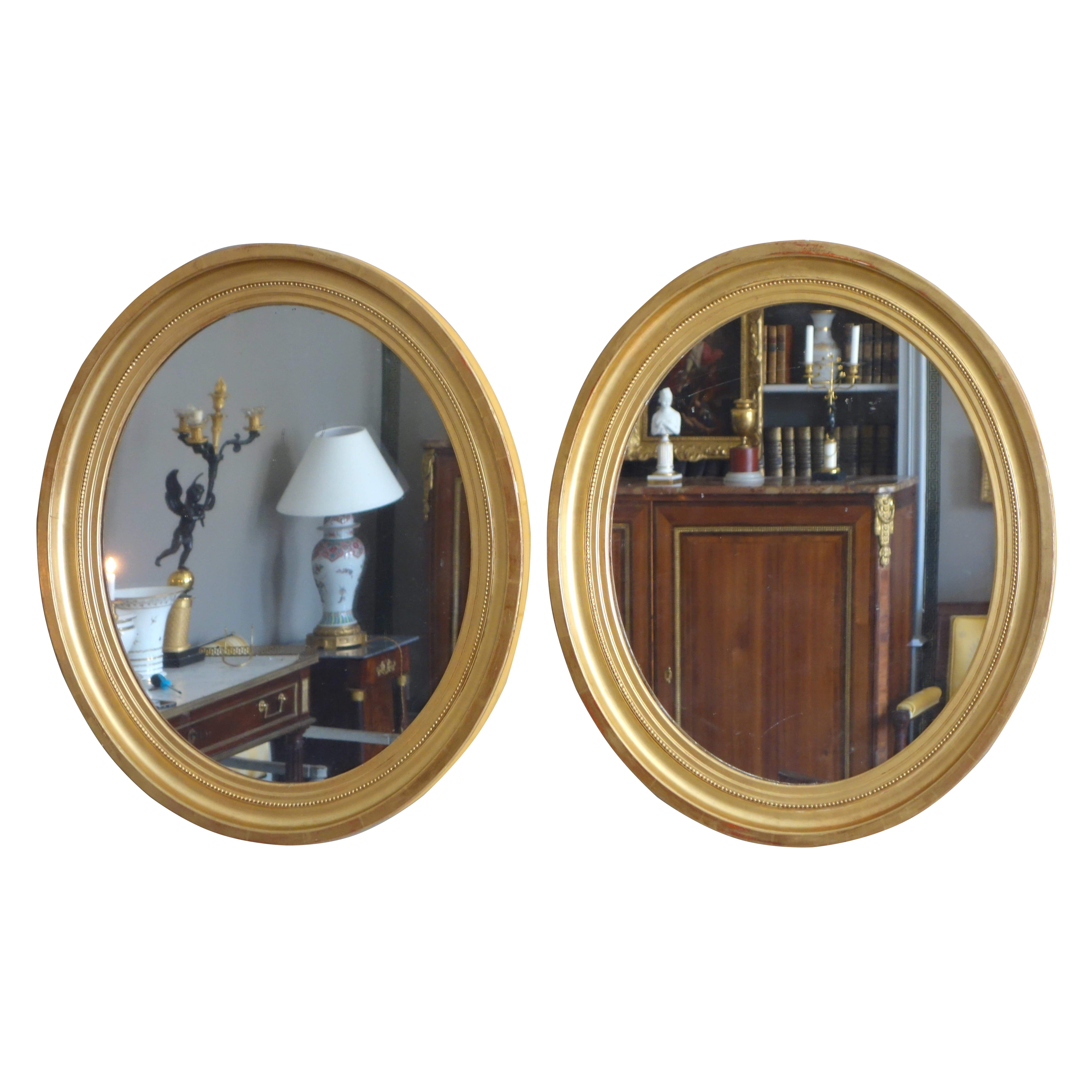 Paire de grands miroirs ovales en bois doré, glace au mercure - style Louis XVI